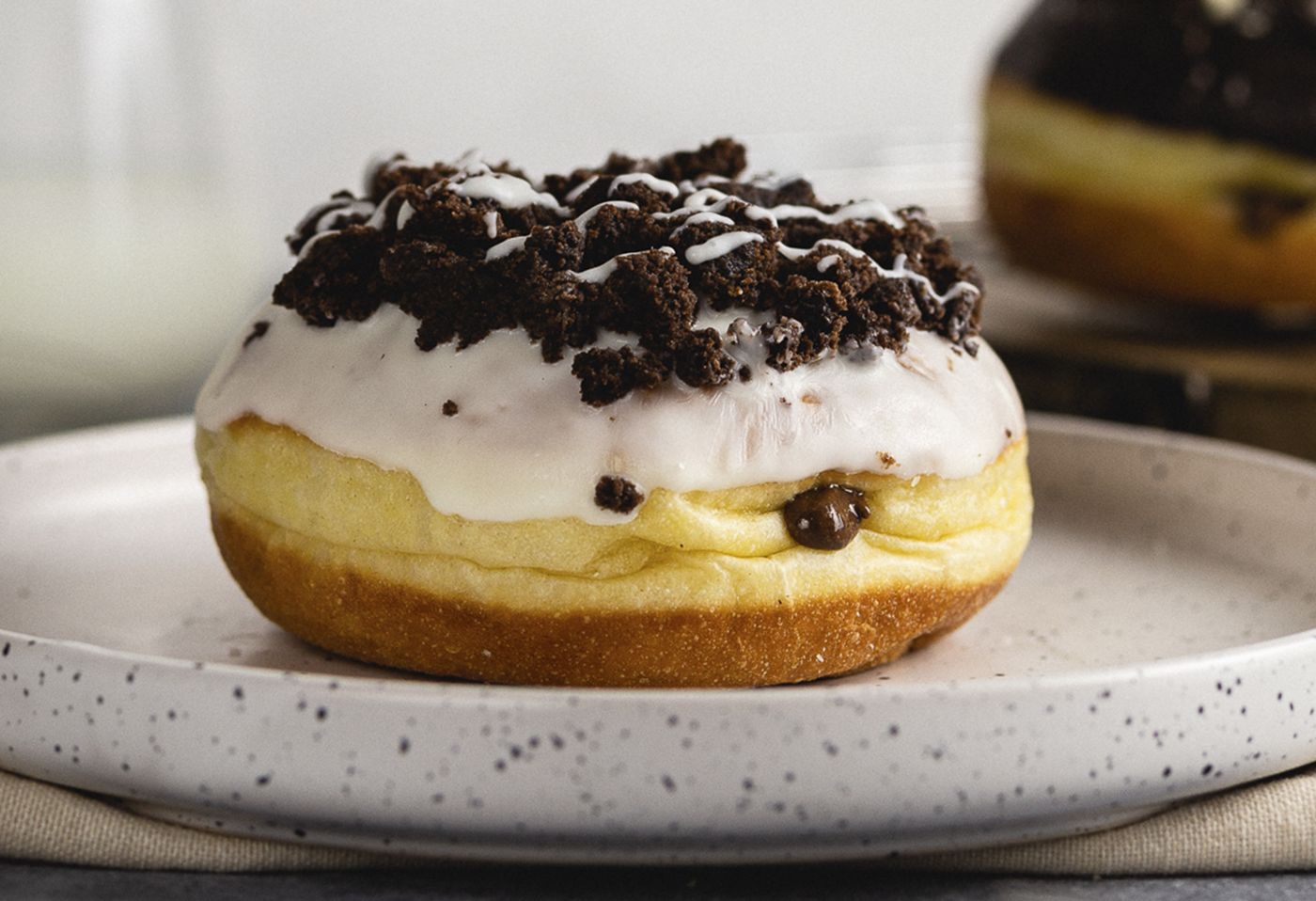 Dona con glaseado blanco y galleta de chocolate triturada